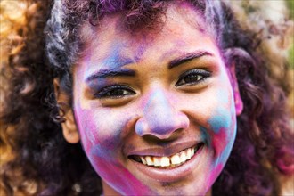 Smiling mixed race woman covered in pigment powder