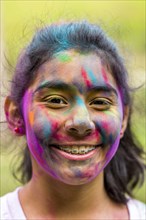 Smiling Hispanic girl covered in pigment powder