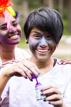 Smiling friends covered in pigment powder