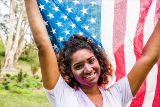 Mixed race woman covered in pigment powder holding American flag