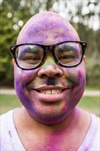 Smiling man covered in pigment powder