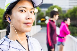 Runner listening to earbud in city