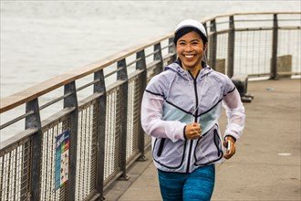 Asian woman running at waterfront