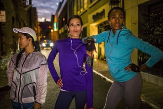 Runners standing on city street at night