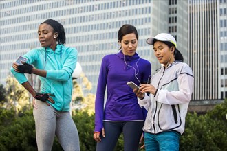 Runners using cell phone near high rise buildings