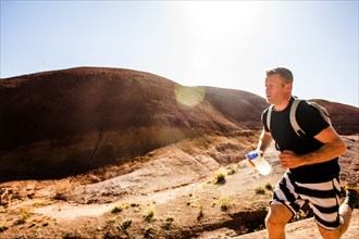 Caucasian man running in desert hills