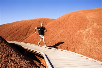 Caucasian man running on walkway in desert hills