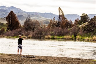 Caucasian man fishing in remote river