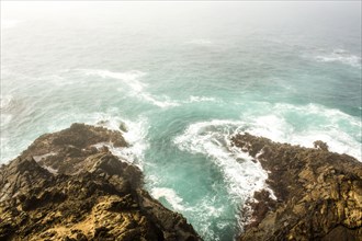 High angle view of ocean waves crashing on cliffs