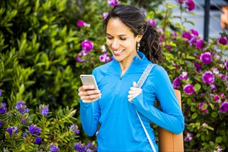 Hispanic woman using cell phone in garden