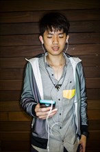 Asian man listening to music with cell phone