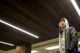 Asian man walking under wooden ceiling