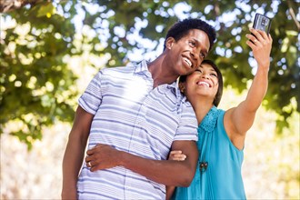 Couple taking selfie with cell phone outdoors