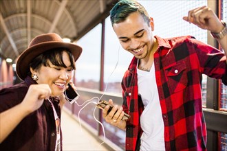 Couple sharing earphones to listen to music