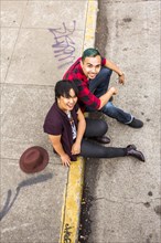 High angle view of couple sitting on curb