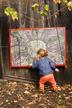 Caucasian baby girl drawing outdoors