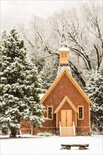 Church and bench in snowy field