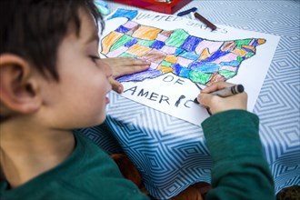 Mixed race boy coloring United States map