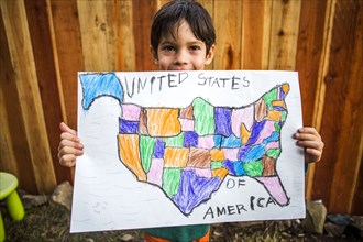 Mixed race boy holding United States map