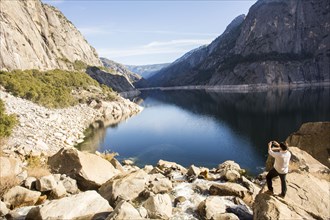 Caucasian man photographing lake in Yosemite National Park
