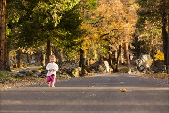 Caucasian baby girl walking on road