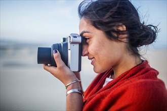 Mixed race woman photographing in desert