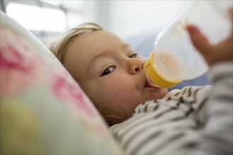 Caucasian baby girl drinking from bottle