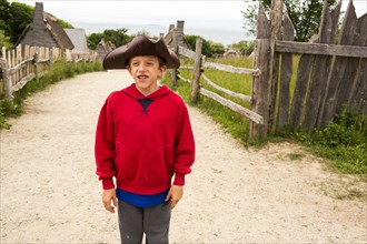 Smiling Caucasian boy posing in tricorn hat on dirt path