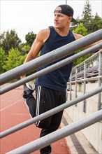 Caucasian man stretching leg at running track