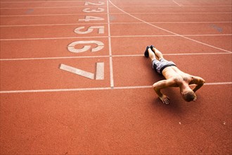 Caucasian man doing push-ups on running track