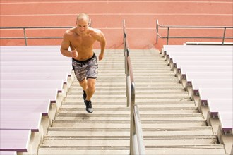 Caucasian man running on staircase on bleachers