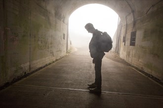 Pensive Caucasian man standing in tunnel