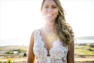 Caucasian bride smiling on sunny day