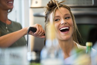 Caucasian woman smiling with hair stylist