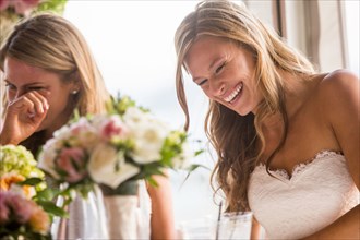 Caucasian brides laughing at table