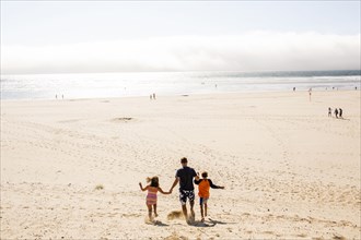 Caucasian family walking on beach