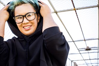 Portrait of smiling androgynous Asian woman wearing hoodie