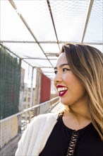 Smiling Asian woman on footbridge