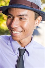 Smiling Mixed Race man wearing fedora