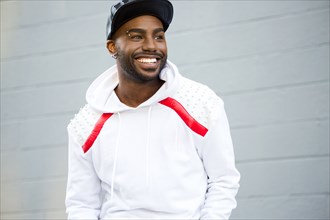 Smiling Black man near gray wall