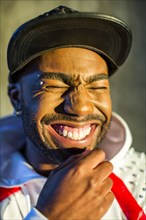 Black man laughing with eyes closed