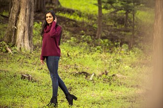Smiling Indian woman posing in forest