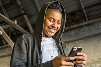 Androgynous Mixed Race woman texting on cell phone
