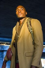Black man wearing backpack holding basketball
