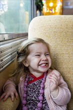 Caucasian girl grinning near window on train
