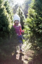 Excited Caucasian girl standing near trees