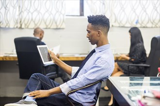 Black man using digital tablet in office