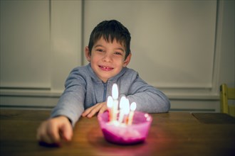 Mixed Race boy smiling near burning candles