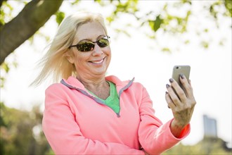 Wind blowing hair of Caucasian woman texting on cell phone
