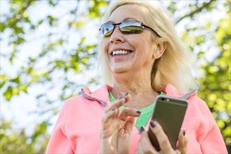 Older Caucasian woman texting on cell phone outdoors